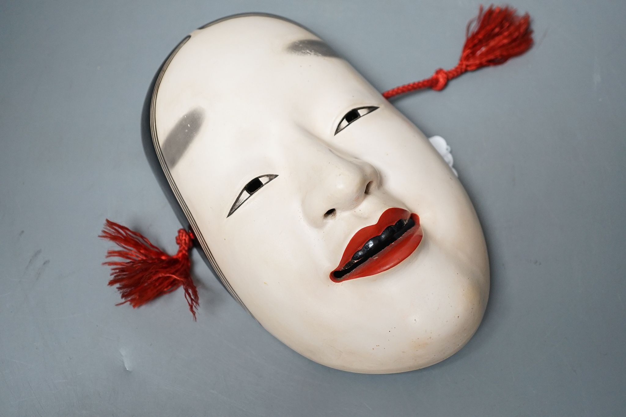 A Japanese pottery Okame noh mask, early 20th century, signed, 19.5 cms high.